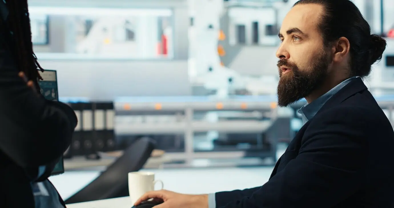 Der Leiter einer Photovoltaikfabrik brainstormt mit einem Kollegen und analysiert dabei Daten.